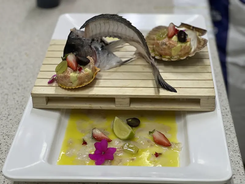 Sea bass carpaccio with tartare in scallop shells, served on a small wooden pallet