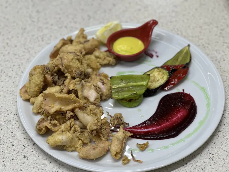 Fried calamari with grilled peppers, a yellow dip and a beetroot purée