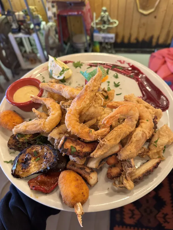 A seafood platter of fried shrimps, grilled octopus and vegetables