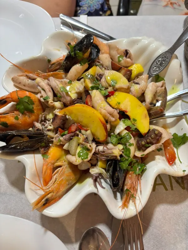 Cold seafood salad with octopus, calamari, shrimps and mussels in a shell-shaped dish