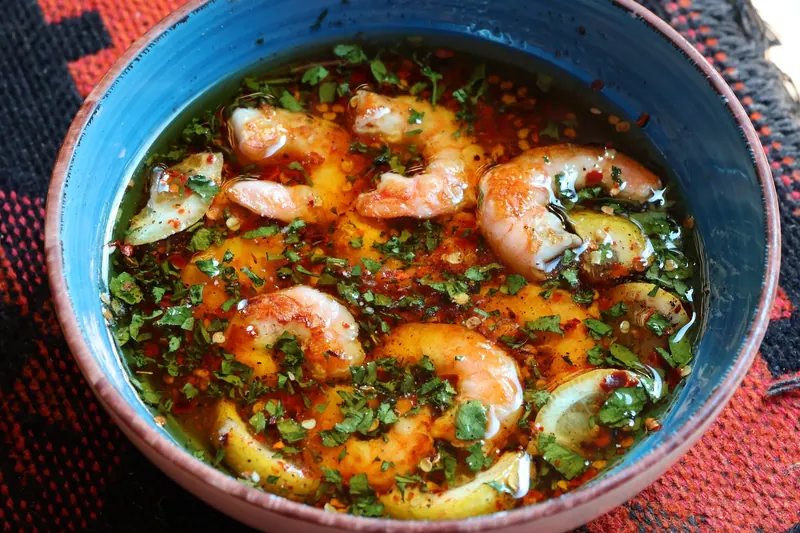 Spicy shrimps in olive oil, lemon, garlic, parsley and chilli, served in a blue bowl